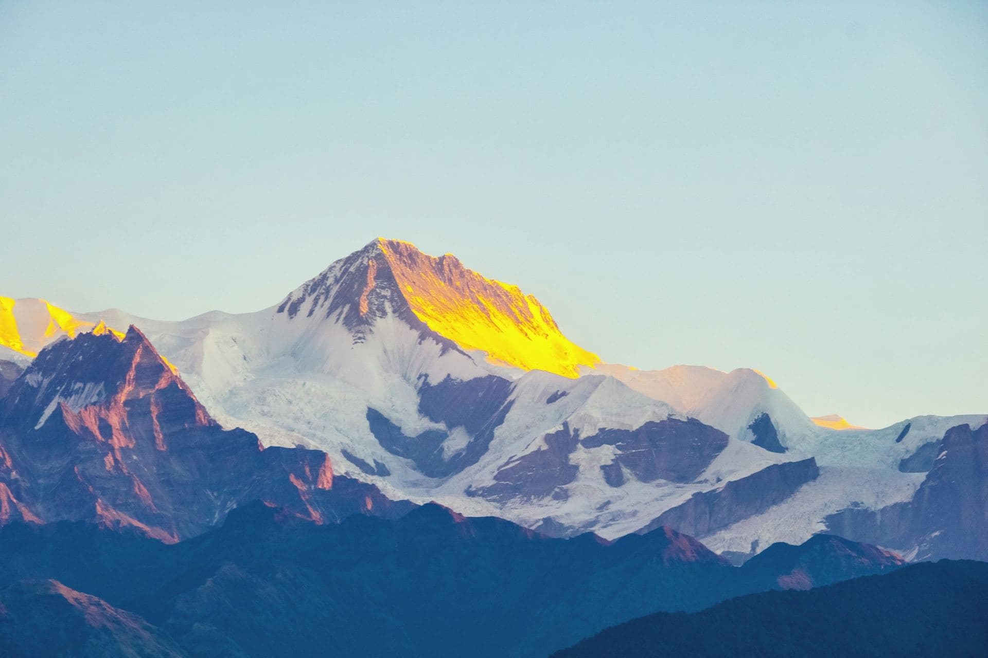 The sharp pyramid of Patalsu Peak seen across the pine ridge above Old Manali, with Hanuman Tibba's snow behind